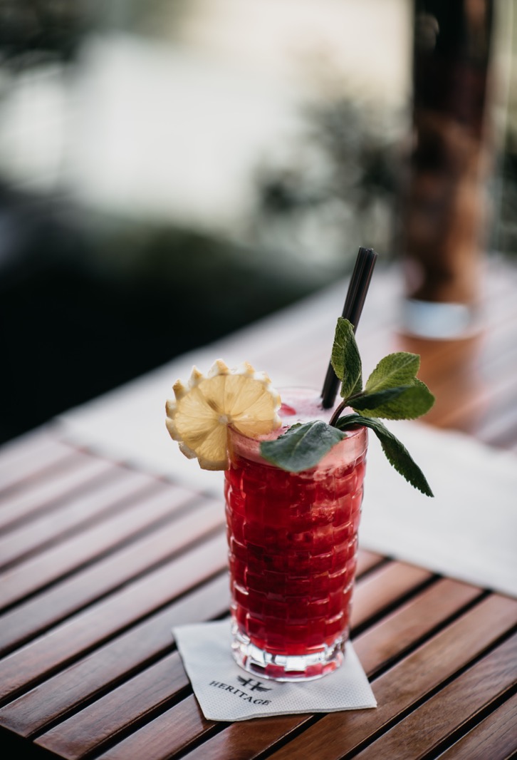 Red cocktail with lemon and mint on the Heritage Rooftop restaurant terrace